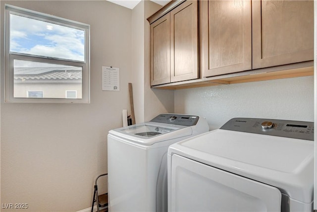 washroom with cabinet space and washing machine and dryer