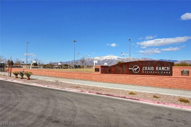 exterior space featuring a mountain view, sidewalks, and curbs