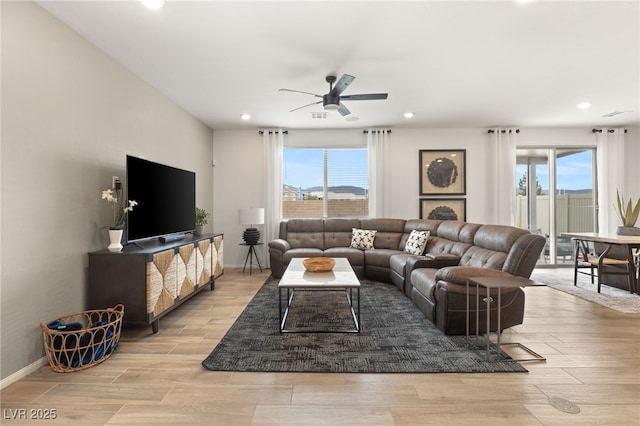 living area featuring recessed lighting, ceiling fan, baseboards, and light wood-style floors