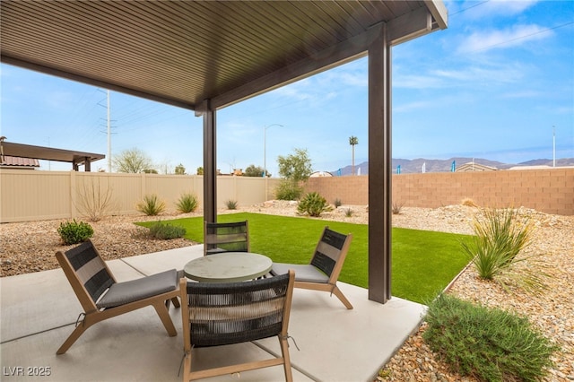 view of patio with a fenced backyard and a mountain view