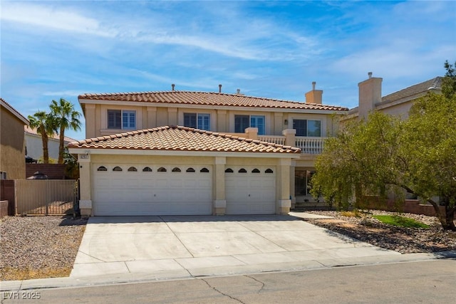 mediterranean / spanish-style house featuring fence, stucco siding, a chimney, an attached garage, and driveway