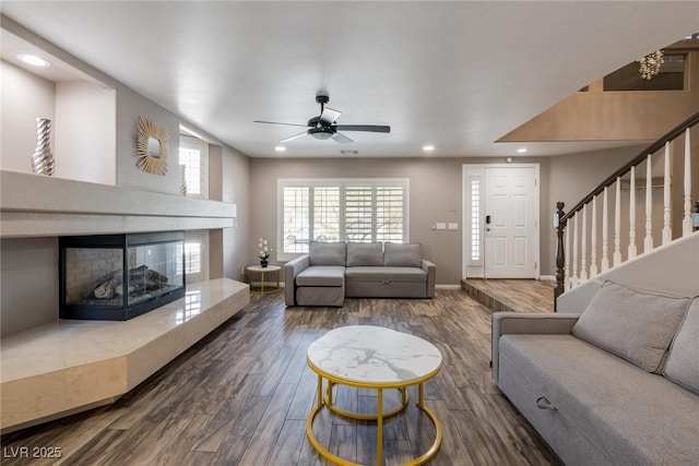 living room with wood finished floors, baseboards, ceiling fan, recessed lighting, and a tile fireplace