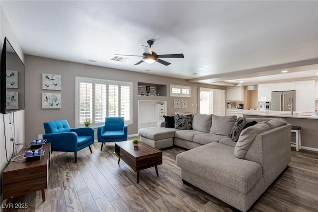 living area with dark wood-style flooring, a ceiling fan, baseboards, recessed lighting, and visible vents