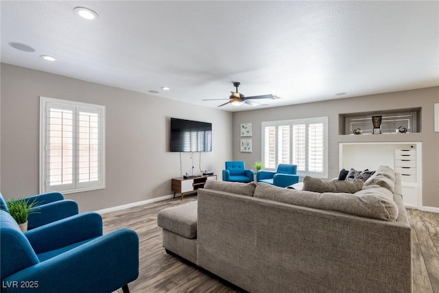 living area with baseboards, ceiling fan, recessed lighting, and wood finished floors