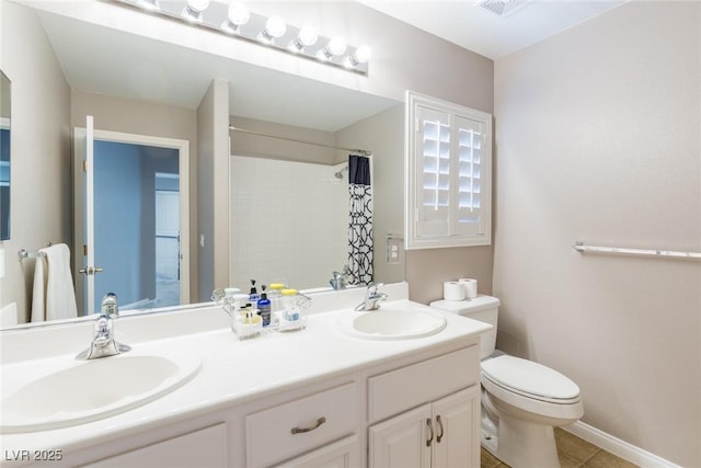 full bath featuring double vanity, a sink, tile patterned floors, and toilet
