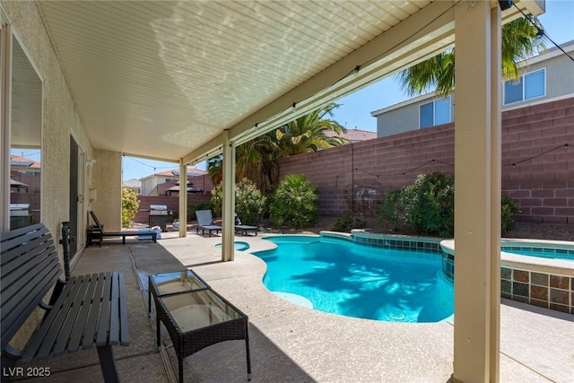 view of pool with a pool with connected hot tub, a fenced backyard, and a patio area