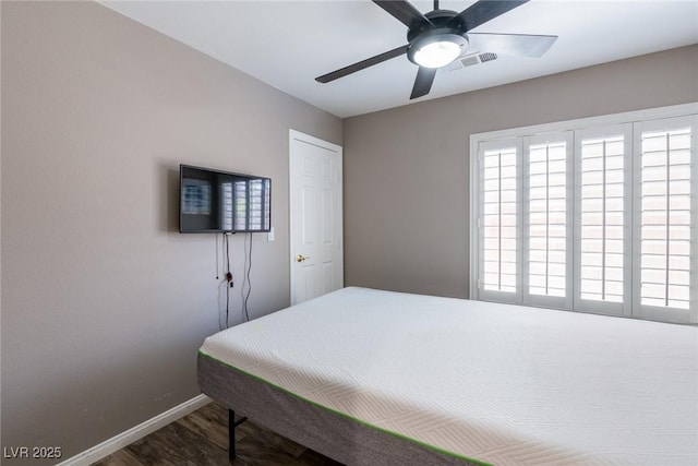 bedroom with baseboards, a ceiling fan, wood finished floors, and visible vents