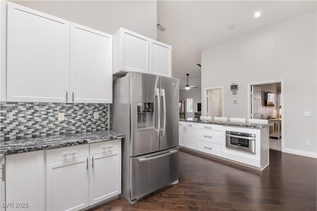 1084 Little House Ct, Henderson, NV 89011 - kitchen featuring white cabinets, appliances with stainless steel finishes, dark stone countertops, tasteful backsplash, and dark wood-style floors