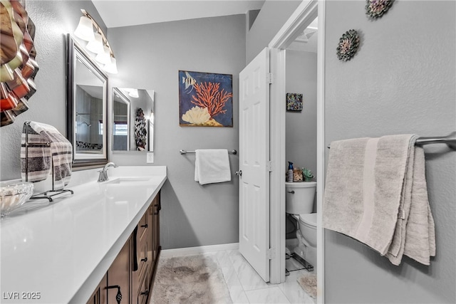 bathroom with vanity, baseboards, toilet, and marble finish floor