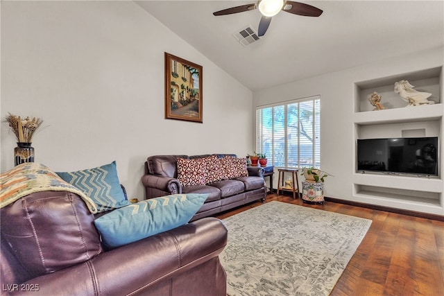 living area with built in shelves, a ceiling fan, wood finished floors, lofted ceiling, and visible vents