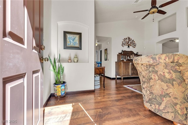 foyer entrance featuring baseboards, a ceiling fan, high vaulted ceiling, and wood finished floors