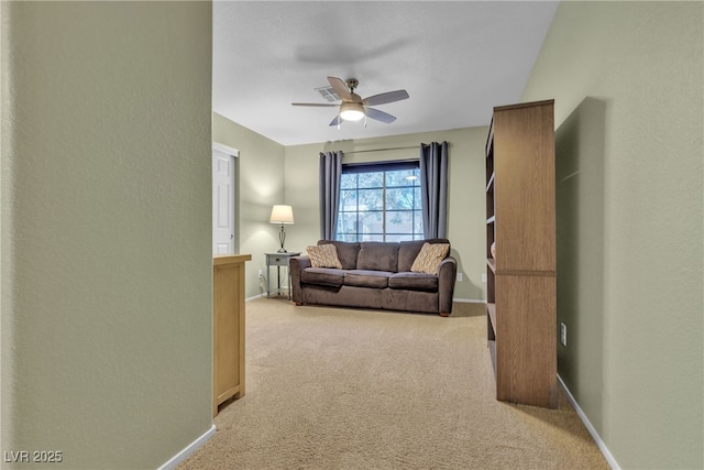 living room featuring baseboards, ceiling fan, and light carpet