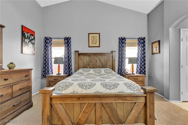 bedroom with light colored carpet, baseboards, and lofted ceiling