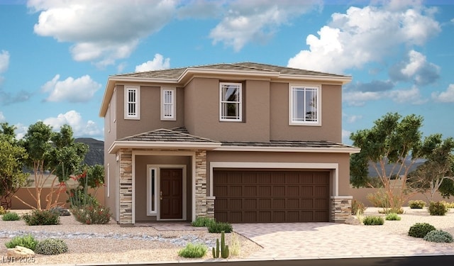 view of front of home featuring a garage, stucco siding, driveway, and stone siding