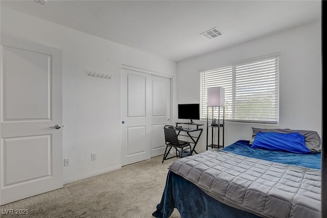 carpeted bedroom with visible vents, baseboards, and a closet