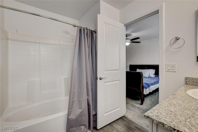 bathroom featuring connected bathroom, vanity, shower / bathtub combination with curtain, a ceiling fan, and wood finished floors