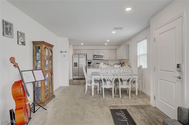 dining room featuring light carpet, recessed lighting, and visible vents