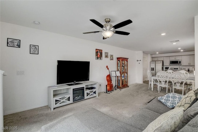 living area with light colored carpet, a ceiling fan, visible vents, and recessed lighting