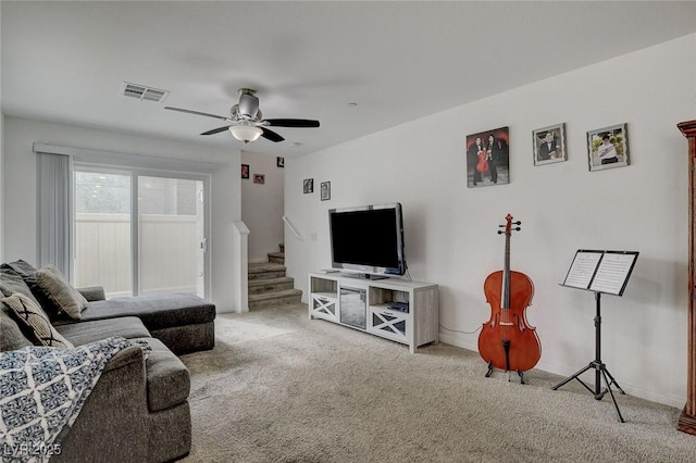 carpeted living room with stairs, ceiling fan, visible vents, and baseboards