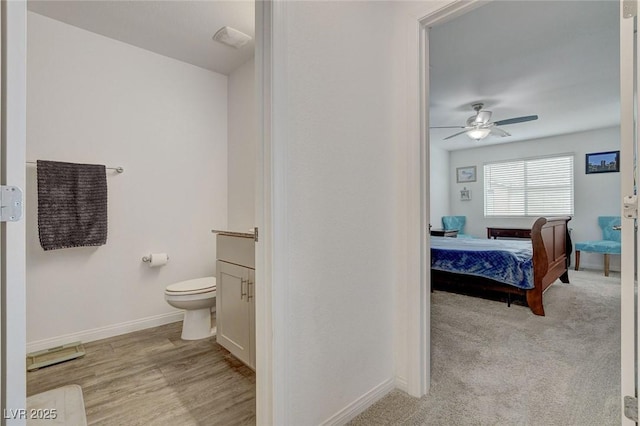 ensuite bathroom featuring baseboards, a ceiling fan, ensuite bath, and toilet