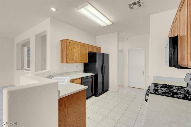 kitchen featuring visible vents, a sink, light countertops, black appliances, and light tile patterned flooring