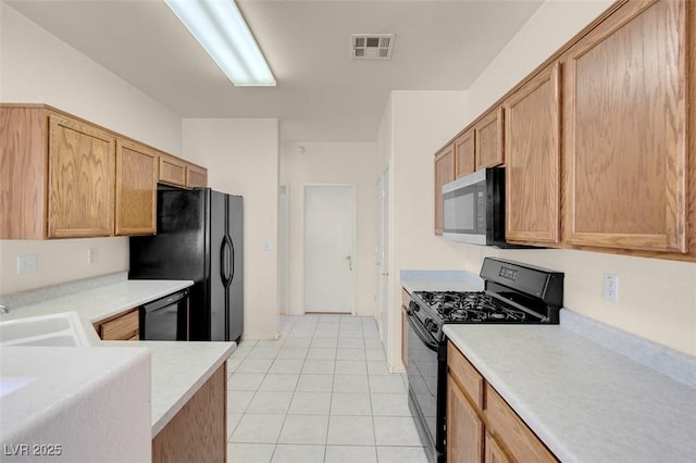 kitchen with light countertops, light tile patterned floors, black appliances, and visible vents