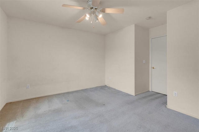 spare room featuring carpet floors, ceiling fan, and baseboards