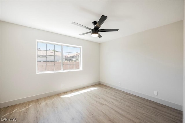 spare room featuring baseboards, a ceiling fan, and wood finished floors