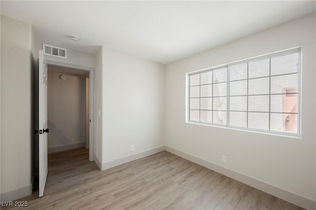 unfurnished bedroom with baseboards, visible vents, and light wood-style floors