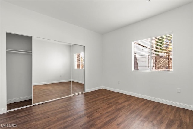 unfurnished bedroom featuring baseboards, a closet, and wood finished floors