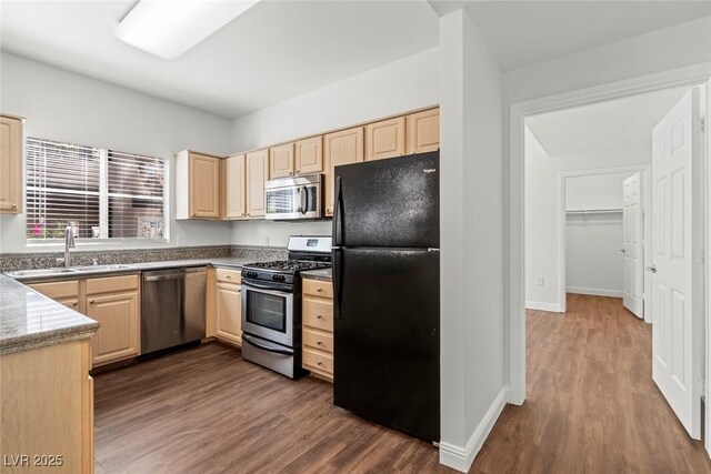kitchen with dark wood-style flooring, light brown cabinets, appliances with stainless steel finishes, and a sink