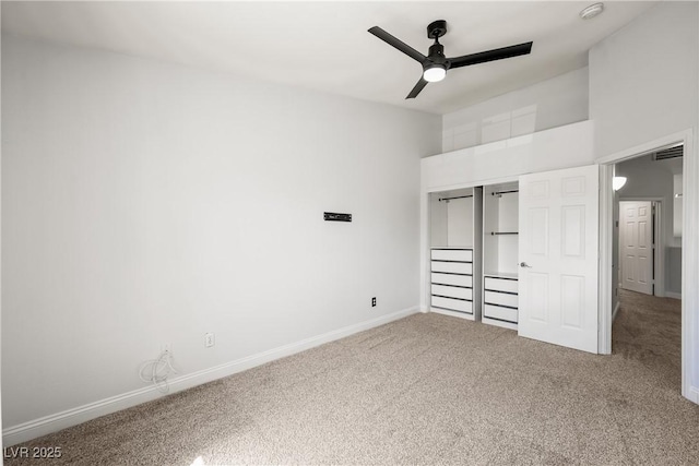 unfurnished bedroom with visible vents, a closet, baseboards, a high ceiling, and carpet flooring