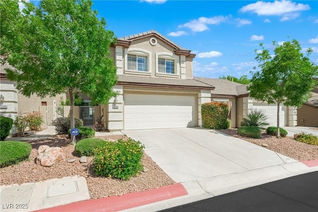 view of front of property with fence, stucco siding, a tiled roof, an attached garage, and driveway