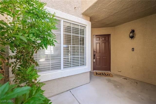 view of exterior entry featuring stucco siding