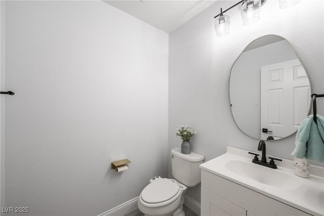 bathroom featuring vanity, baseboards, and toilet