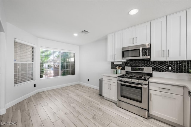 10244 Amber Hue Ln, Las Vegas, NV 89144 - kitchen with appliances with stainless steel finishes, light countertops, baseboards, backsplash, and visible vents