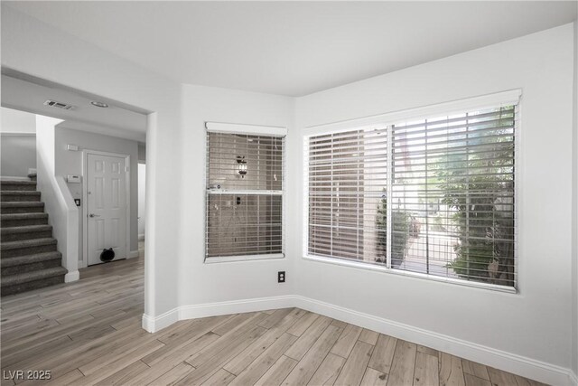 10244 Amber Hue Ln, Las Vegas, NV 89144 - empty room with baseboards, light wood-style flooring, visible vents, and stairway