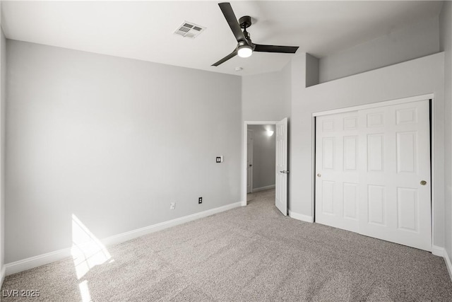 unfurnished bedroom with baseboards, light colored carpet, visible vents, and a closet