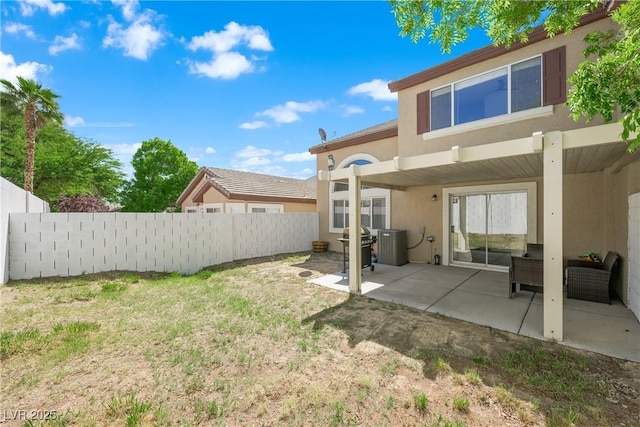 rear view of property featuring stucco siding, a patio area, fence, and a lawn