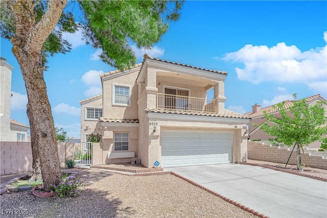 mediterranean / spanish-style house with fence, an attached garage, a tile roof, stucco siding, and concrete driveway
