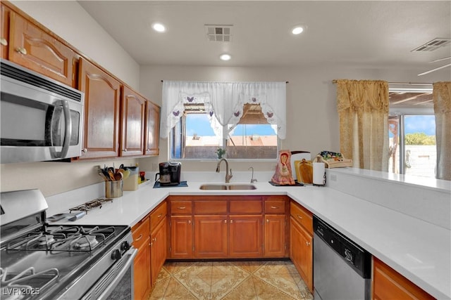 kitchen with visible vents, a sink, appliances with stainless steel finishes, and light countertops