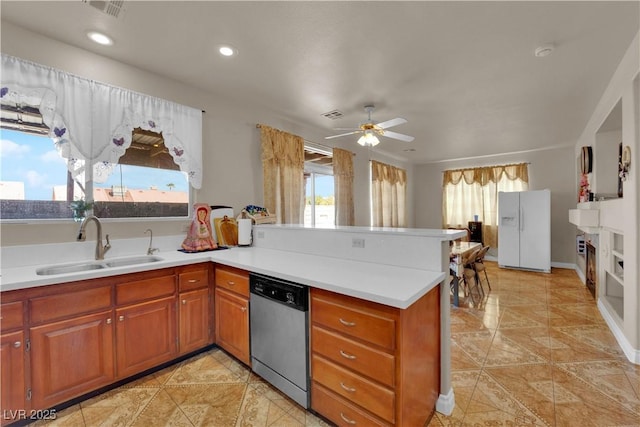 kitchen with stainless steel dishwasher, a sink, light countertops, a peninsula, and white fridge with ice dispenser