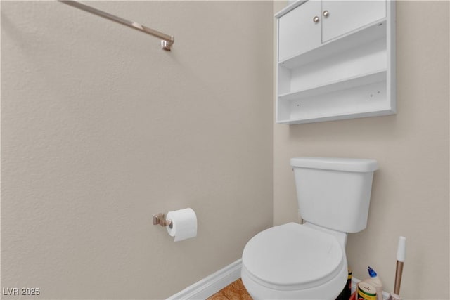 bathroom featuring baseboards and toilet