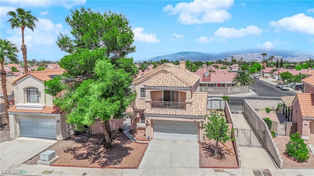 view of front of house with an attached garage, driveway, a tile roof, and stucco siding