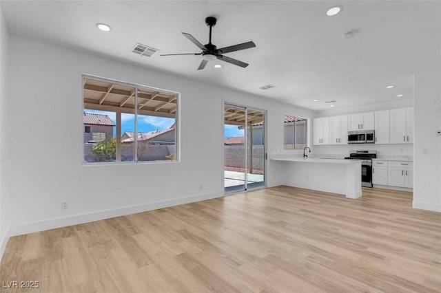 8725 Russet Hills Ct, Las Vegas, NV 89147 - unfurnished living room featuring recessed lighting, light wood-style floors, baseboards, ceiling fan, and a sink