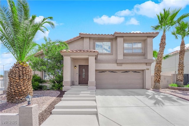mediterranean / spanish house with a tiled roof, an attached garage, driveway, and stucco siding