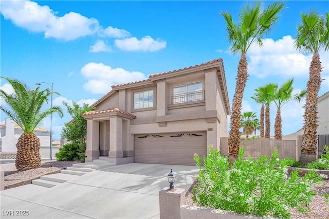 mediterranean / spanish-style house with a garage, fence, stucco siding, concrete driveway, and a tile roof