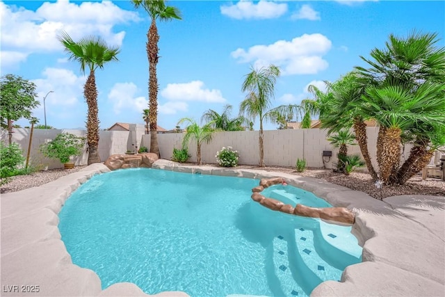view of swimming pool with a fenced backyard and a pool with connected hot tub