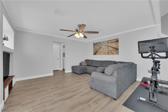 living area featuring ceiling fan, visible vents, wood finished floors, baseboards, and ornamental molding