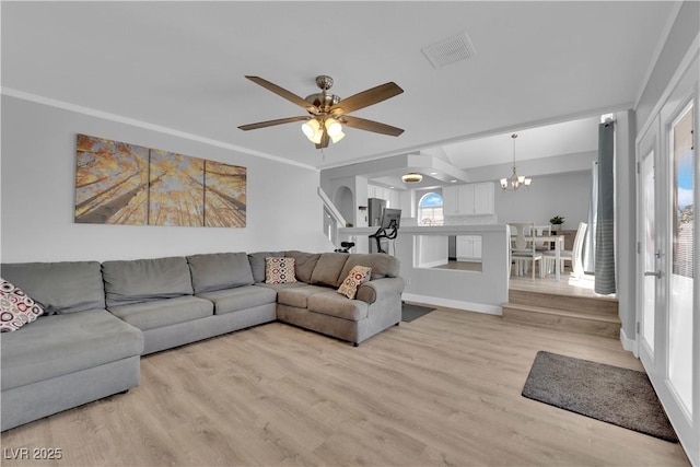 living room featuring visible vents, light wood-style flooring, and ceiling fan with notable chandelier